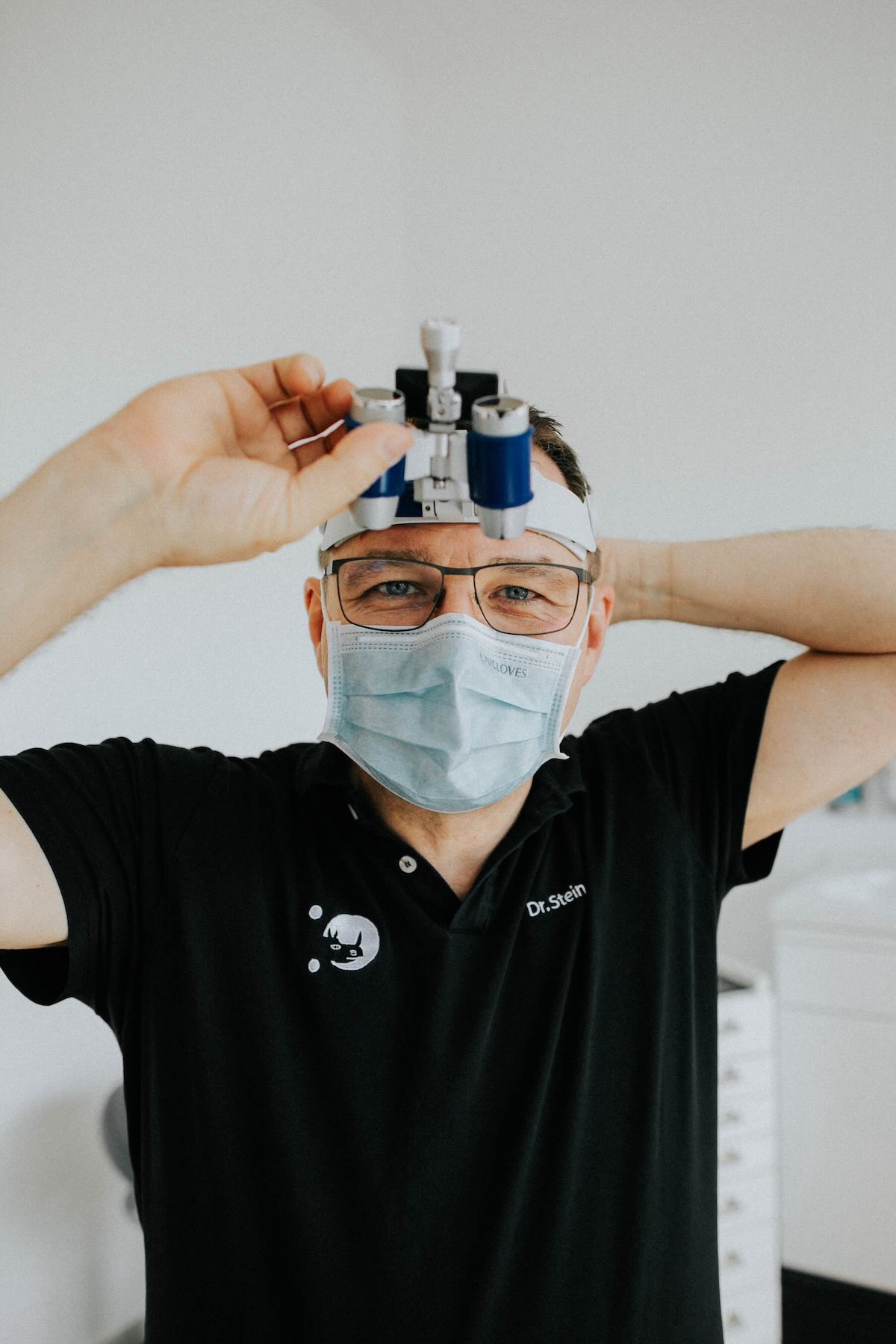 Dr. Stein richtet die Lupenbrille für eine Implantatbehandlung